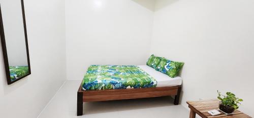una cama en una habitación con una pared blanca en Hey Mojo Guest House by Bantayan Summerhouse, en Pooc