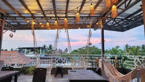 Un patio con sillas y mesas y una vista en Hey Mojo Guest House by Bantayan Summerhouse, en Pooc