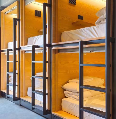 a room with bunk beds in a dorm room at The Capsule Hakuba in Hakuba