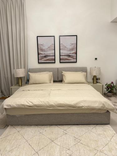 a bedroom with a large bed with two pictures on the wall at Yas island Golf collections in Abu Dhabi