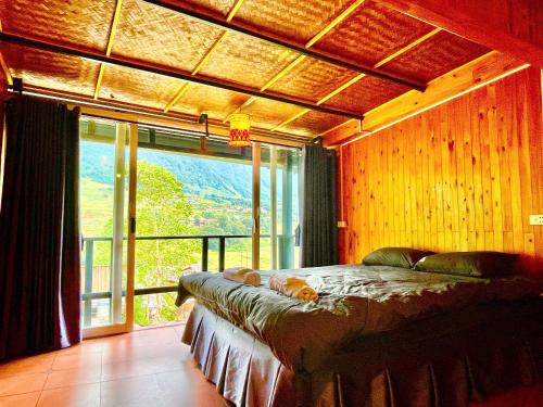 a bedroom with a bed and a large window at Sky View hostel in Sapa