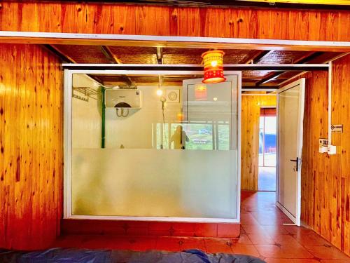 a glass window in a room with wooden walls at Sky View hostel in Sapa