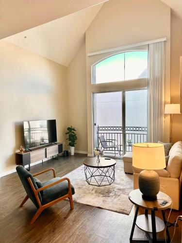a living room with a large window and a couch at Spacious 2B 2B Pool View Loft Apartment in Marina Del Rey in Los Angeles