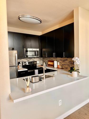 a kitchen with black cabinets and a white counter top at Spacious 2B 2B Pool View Loft Apartment in Marina Del Rey in Los Angeles