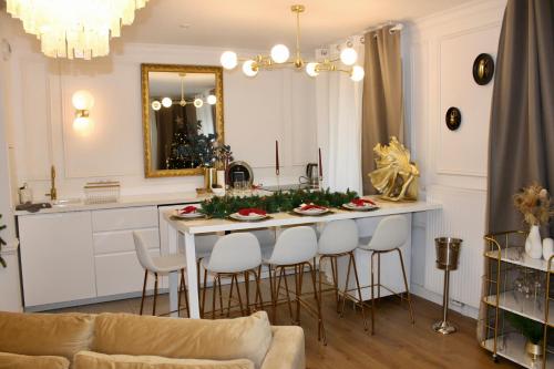 a kitchen with a table and stools in a room at Suite de Luxe à 10 min de Paris - Sauna, Cinéma in Bagneux