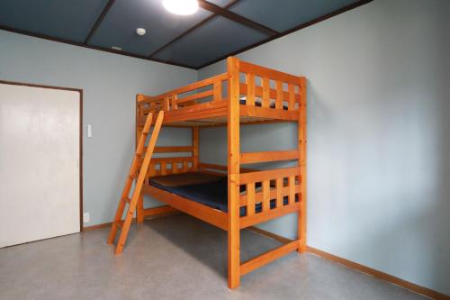 a wooden bunk bed in the corner of a room at ひだまりの宿 まゆしょう in Wada