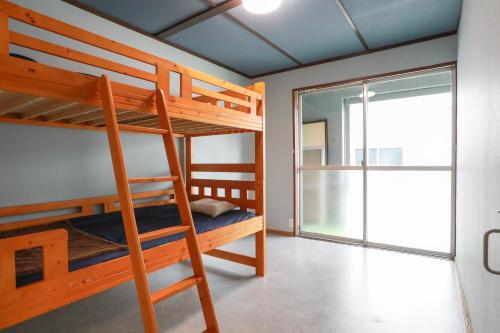 a bunk bed room with two bunk beds and a window at ひだまりの宿 まゆしょう in Wada