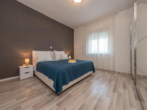 a bedroom with a bed with a blue blanket and two lamps at Villa in Galovac with Pool near Zadar in Galovac