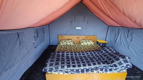una camera da letto in una tenda con un letto di Rooftop Campsite Munsyari a Munsyari