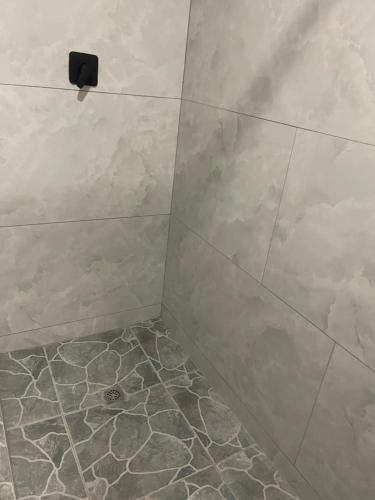 a bathroom with a shower with a tiled floor at Tucked away with a pool view in White River