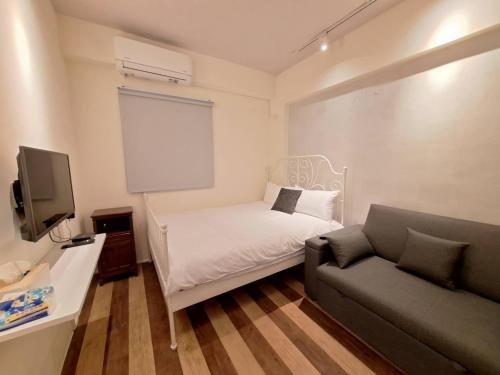 a small room with a bed and a couch at 芳心蘭厝民宿花境館 in Wujie