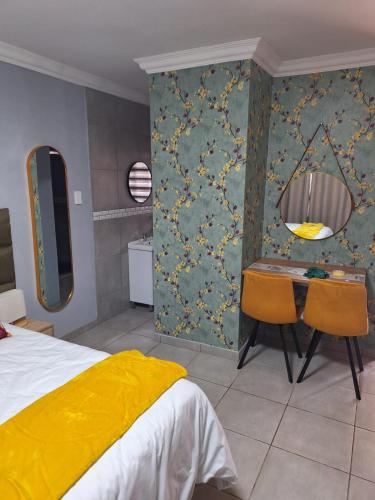 a bedroom with a bed and a table and chairs at 310 Bonnyvale in Kempton Park