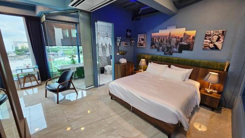a bedroom with a bed and a chair in it at BlueTel Re'sidencE Bangkok IMPACT บลูเทล เรซิดองส์ กรุงเทพ อิมแพค in Nonthaburi