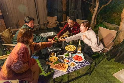 a group of people sitting around a table with food at f life house in Koriyama