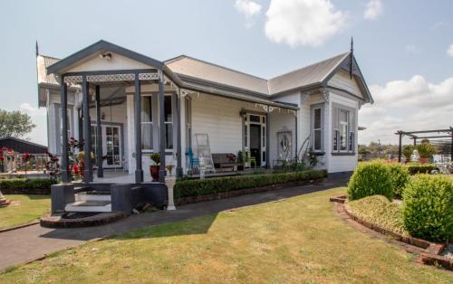 a white house with a porch and a lawn at The Homestead - a rural family retreat in Sentry Hill