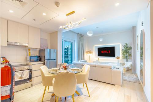 a kitchen and living room with a table and chairs at Modern 1-Bed Apartment with Balcony & Free Parking l Near Yas Mall & F1 Yas Island & Sea world in Abu Dhabi