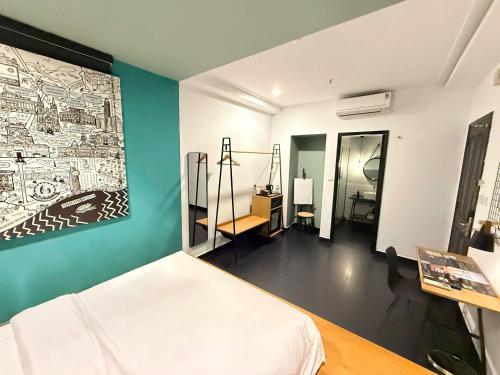 ein Schlafzimmer mit einem Bett und einem Gemälde an der Wand in der Unterkunft The Hammock Hotel Fine Arts Museum in Ho-Chi-Minh-Stadt
