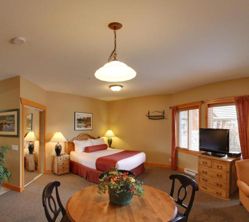 ein Hotelzimmer mit einem Bett und einem Tisch in der Unterkunft Lizard Creek Lodge in Fernie