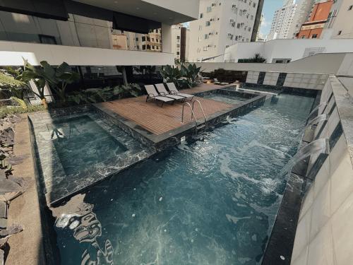 a swimming pool on the side of a building at Apartamento 3 dormitórios quadra da praia in Balneário Camboriú