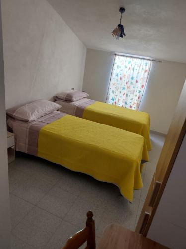 two beds with yellow covers in a room at Casa vacanze nel Parco della Majella in Montenerodomo