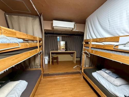 two bunk beds in a room with a desk at Male-only dormitory Tokyo House INN in Tokyo