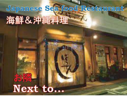 a sign for a japanese sea food restaurant next to a store at El Sol Town Okinawa in Chatan