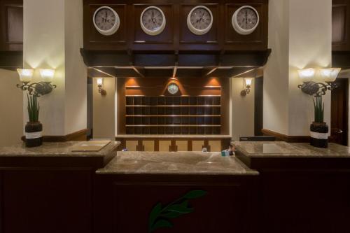 a bathroom with a sink with clocks on the wall at Espacio Verde Resort in Roxas City