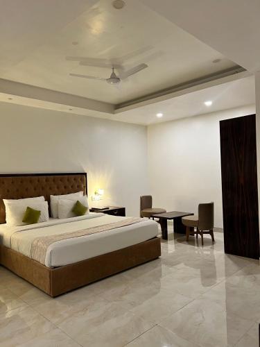 a bedroom with a bed and a table and chairs at Grand Tulsi in Nānded