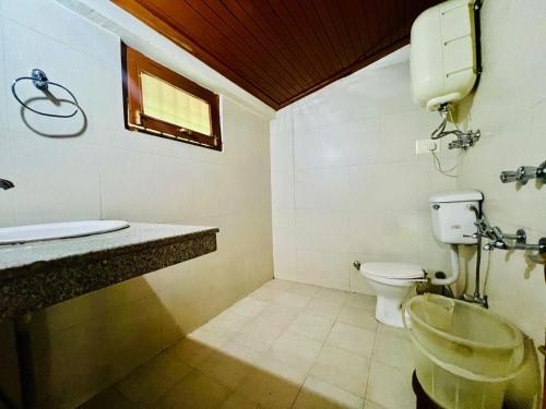 un baño con inodoro y lavabo en Hotel Inn Way #Near Beas River, en Manali