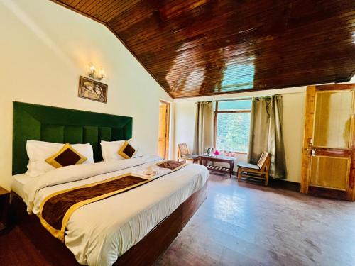 Un dormitorio con una cama grande con cabecero verde. en Hotel Inn Way #Near Beas River, en Manali