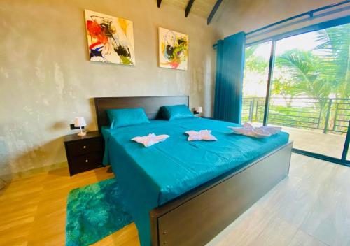 ティッサマハーラーマにあるLake Breeze Cabana Yalaの青いベッドとピンクのタオルが2枚置かれた寝室