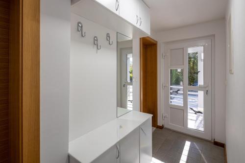 a white kitchen with white cabinets and a staircase at Villa 5 elements in Gostinjac