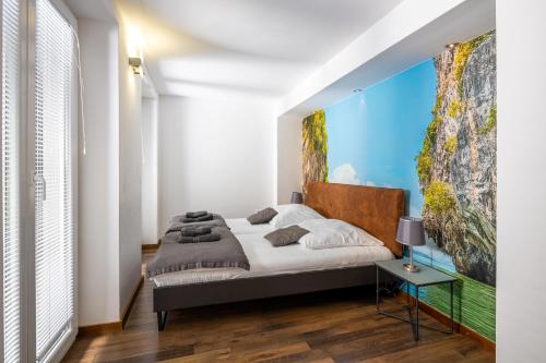 a bedroom with a bed with a large painting on the wall at Villa 5 elements in Gostinjac