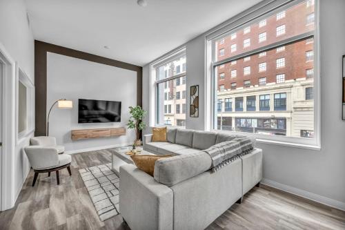 a living room with a couch and a large window at Luxe Flat with Heated Pool Sauna Rooftop Deck Gym in Cleveland