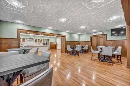 a dining room with tables and chairs and a kitchen at Luxe Flat with Heated Pool Sauna Rooftop Deck Gym in Cleveland