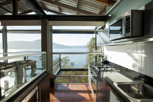 a kitchen with a view of the water at The Pavilions at Mona in Hobart