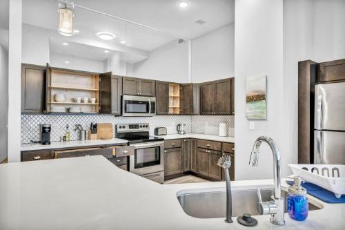 クリーブランドにあるLuxe Flat with Heated Pool Sauna Rooftop Deck Gymのキッチン(ステンレス製の電化製品、木製キャビネット付)