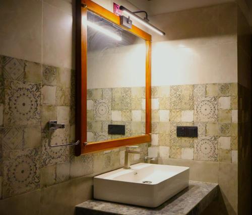 ein Badezimmer mit Waschbecken und Spiegel in der Unterkunft Cinnamon Breeze Villa in Kandy