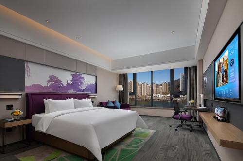 a bedroom with a large white bed and a tv at Hilton Garden Inn Chengde Mountain Resort in Niuquanzigou