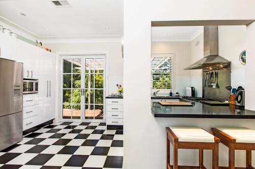 una cocina con suelo a cuadros en blanco y negro en Winston Cottage at Three Sisters, en Katoomba