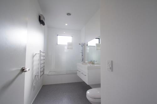 a white bathroom with a toilet and a sink at Nordic Escape - Lake Tekapo in Lake Tekapo