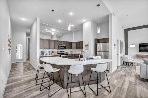 クリーブランドにあるLuxe Flat with Heated Pool Sauna Rooftop Deck Gymのキッチン(大きな白いテーブルと椅子付)