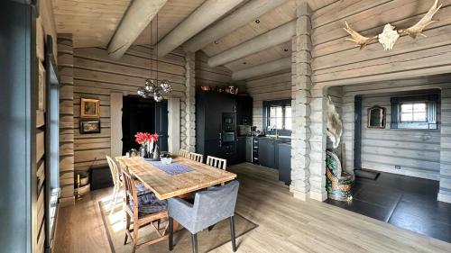 a dining room with a wooden table in a cabin at Cozy Log Cabin With A View Over Hedmarken in Løten