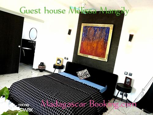 a bedroom with a bed and a painting on the wall at Studio vue sur brousse in Toliara