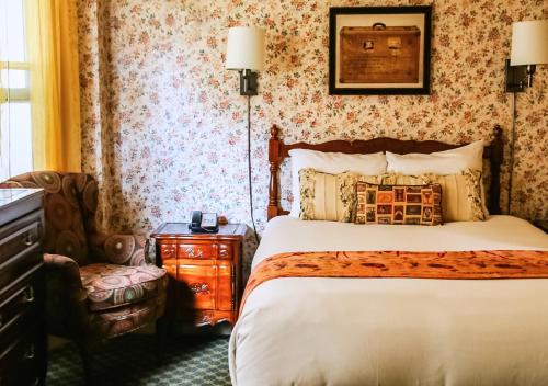 a hotel room with a bed and a chair at Petite Auberge in San Francisco