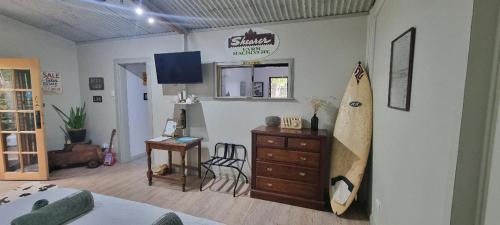 a room with a room with a surfboard on the wall at Polly's Retreat in Coffin Bay