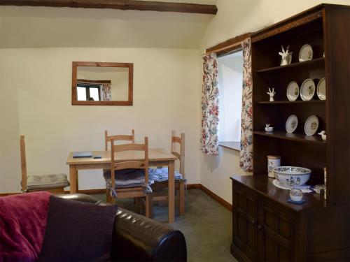 ein Wohnzimmer mit Tisch und ein Esszimmer in der Unterkunft Hazel Cottage in Ambleside