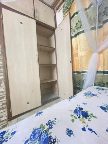 a room with a bed and open cabinets at Danfo in Mto Panga