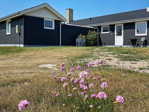 Torstedにある6 person holiday home in Thistedの庭前のピンクの花の家