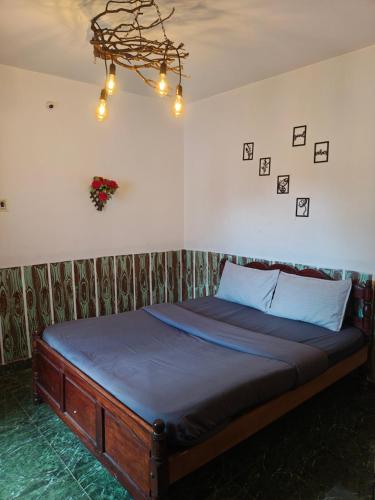 a bedroom with a bed with blue sheets and a chandelier at kMT ooty villa mangal niketen in Ooty